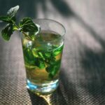 Tazza di tè alla menta su un tavolo, con un grafico che mostra variazioni della pressione sanguigna.