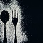 Farina di riso in una ciotola con un cucchiaio, rappresenta l'argomento di colesterolo e glicemia.