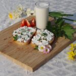 Ricotta fresca servita in un piatto con erbe aromatiche, simbolo di salute e benessere.