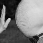 Immagine che illustra le cause del gonfiore addominale continuo con diagrammi e testi informativi.